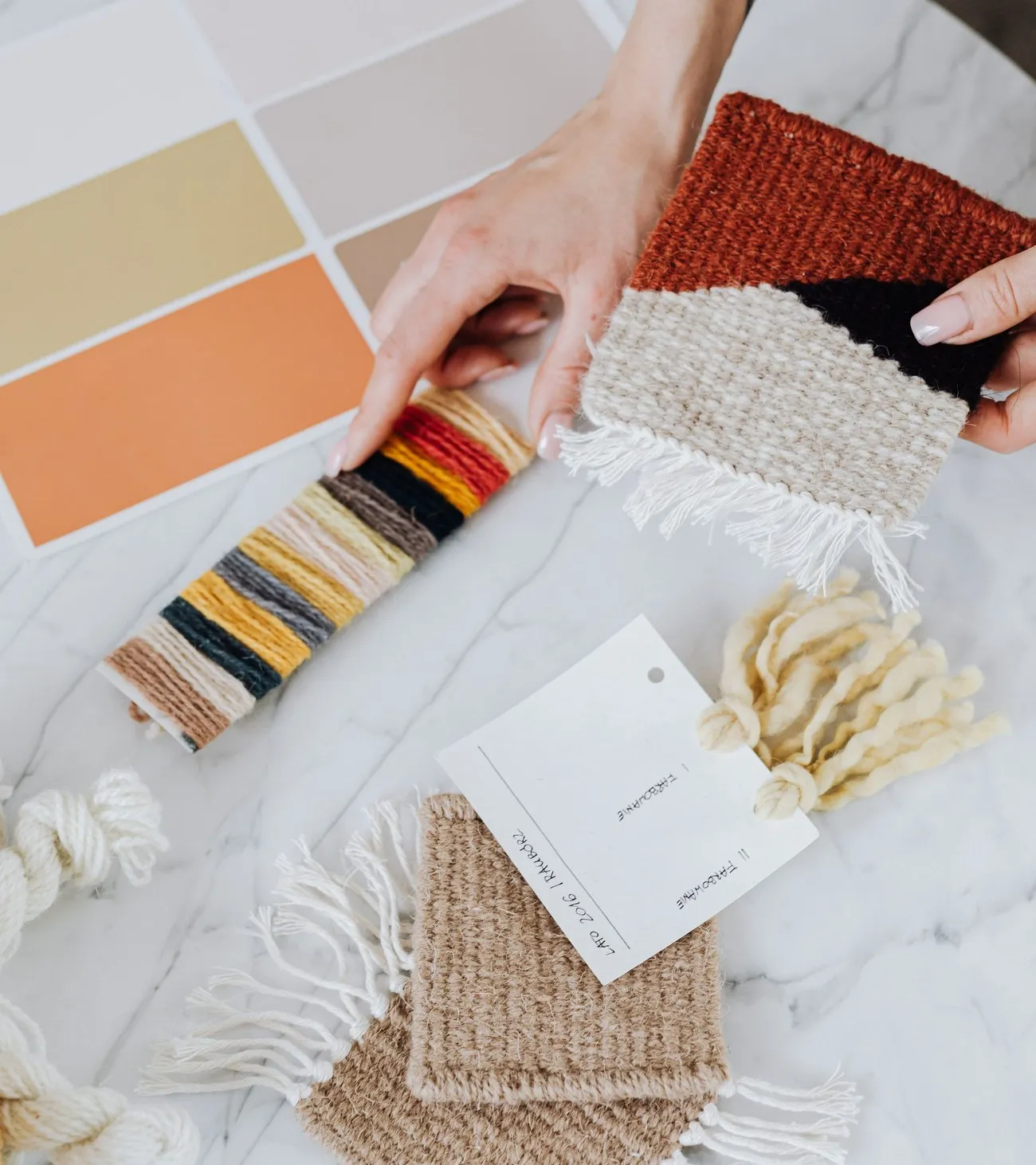 Tangan memilih contoh warna dan kain di atas meja